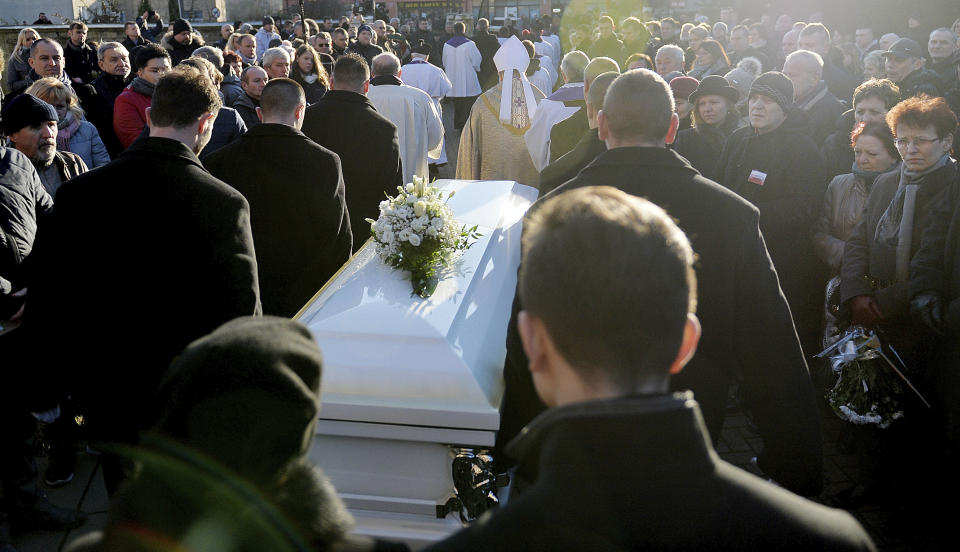 People gather in front of the church after a funeral mass for the Polish truck driver Lukasz Urban, who was killed in the Berlin Christmas market attack, in the church in Banie, Poland, Friday, Dec. 30, 2016. (AP Photo/Lukasz Szelemej)