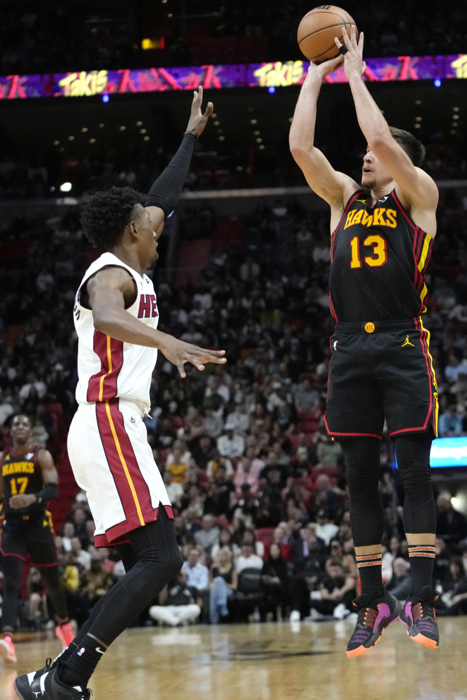 Atlanta Hawks guard Bogdan Bogdanovic (13) attempts a 3-pointer as Miami Heat guard Josh Richardson defends during the first half of an NBA basketball game Friday, Dec. 22, 2023, in Miami. (AP Photo/Lynne Sladky)