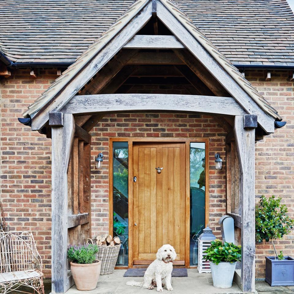 front of house with porch and dog sitting in front