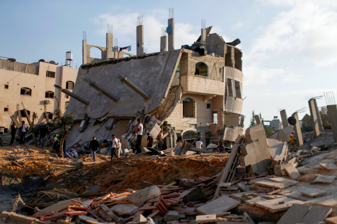 Palestinians gather around the ruins of buildings which were destroyed in Israeli air strikes amid a flare-up of Israeli-Palestinian violence, in the northern Gaza Strip. (Reuters/Mohammed Salem)