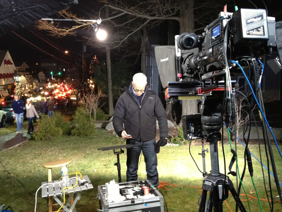 CNN's Anderson Cooper checks his phone in between live shots in Newtown, Conn.