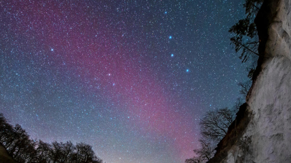 A hazy red streak of light in the night sky