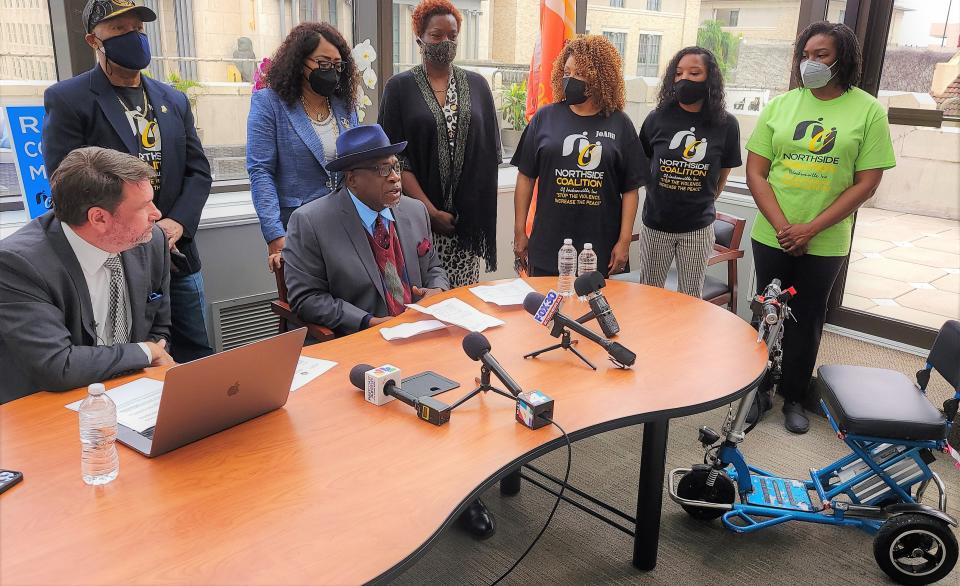 Jacksonville community activist Ben Frazier (center seated) speaks at a Monday news conference regarding actions being considered following his handcuffed escort from a Jan. 4 governor's news conference. Joined by attorney John Phillips (left), they are asking police to drop the trespass charge and want the governor to agree to a meeting.