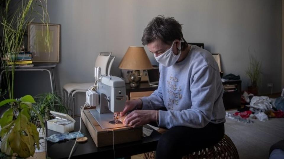 Un hombre en una máquina de coser