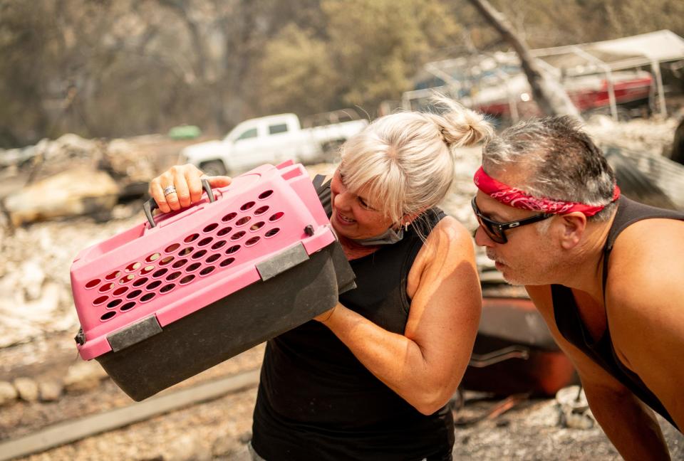 Katie Giannuzzi is elated to find her cat Gus in a drain amid the burned remains of her home during the LNU Lightning Complex Fire in Vacaville, Calif., on Aug. 23.