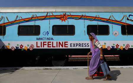 A patient walks past the Lifeline Express, a hospital built inside a seven-coach train, parked at a railway station in Jalore, India, March 31, 2018. REUTERS/Danish Siddiqui