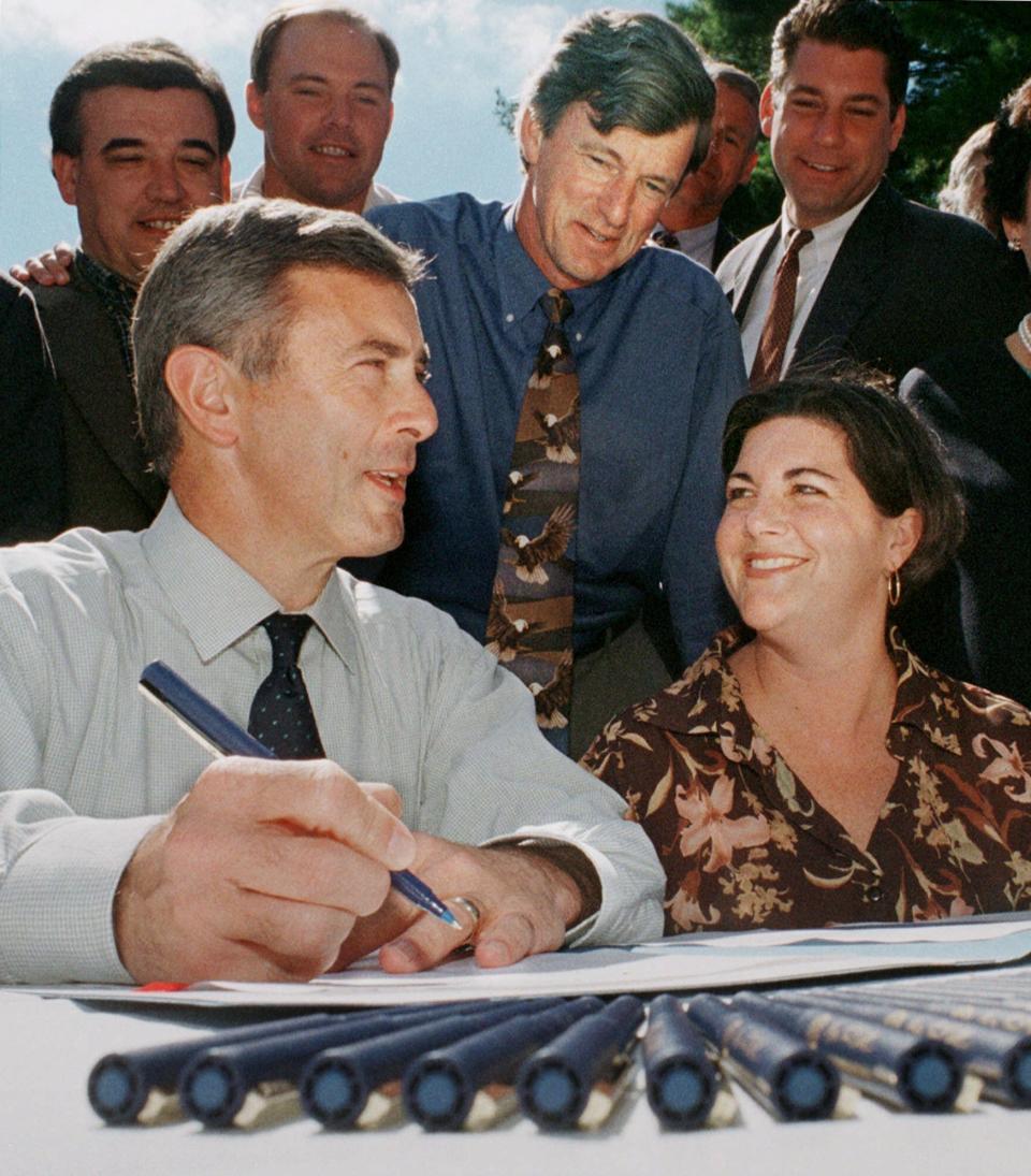 Then-Massachusetts Gov. Paul Cellucci, left, and former Lt. Gov. Jane Swift, right, share a light moment as former Mass. Environmental Affairs Secretary Bob Durand, center, looks on during the Community Preservation Act signing ceremony in 2000 in Waltham.  