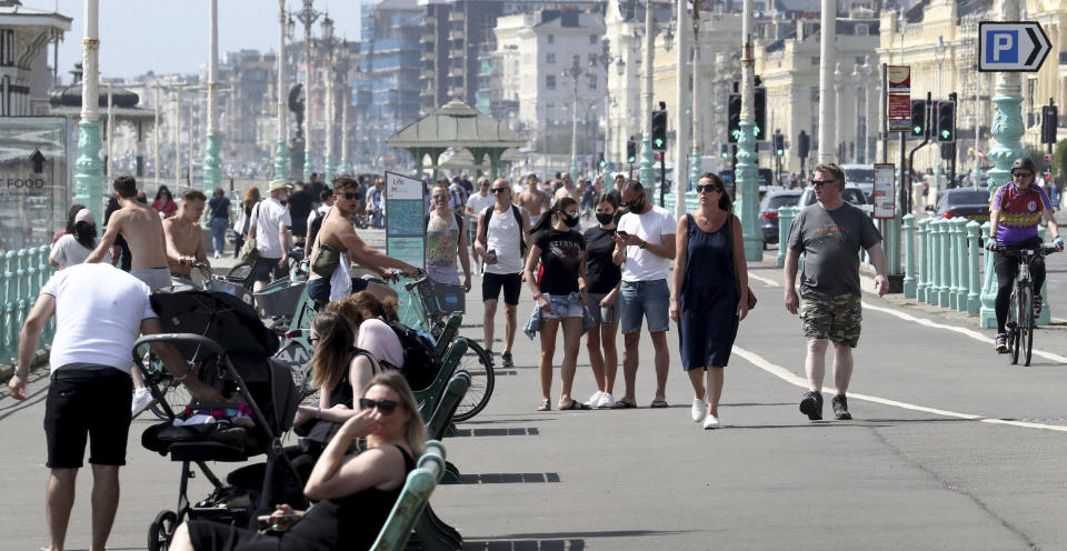 People on the promenade during the warm weather in Brighton in East Sussex, England as the UK continues in lockdown to help curb the spread of the coronavirus, Saturday May 9, 2020. (Gareth Fuller/PA via AP)