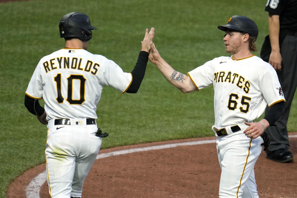 Pittsburgh Pirates' Jack Suwinski (65) and Bryan Reynolds celebrate after scoring on a single by Ke'Bryan Hayes off Arizona Diamondbacks starting pitcher Zac Gallen during the fourth inning of a baseball game in Pittsburgh, Friday, May 19, 2023. (AP Photo/Gene J. Puskar)