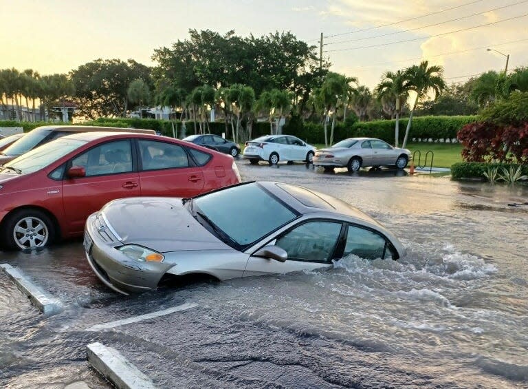 Kings Point resident Ingrid Robinson's 2002 Honda Civic falls into a sinkhole caused by a water main break at the Flanders E apartment complex.
