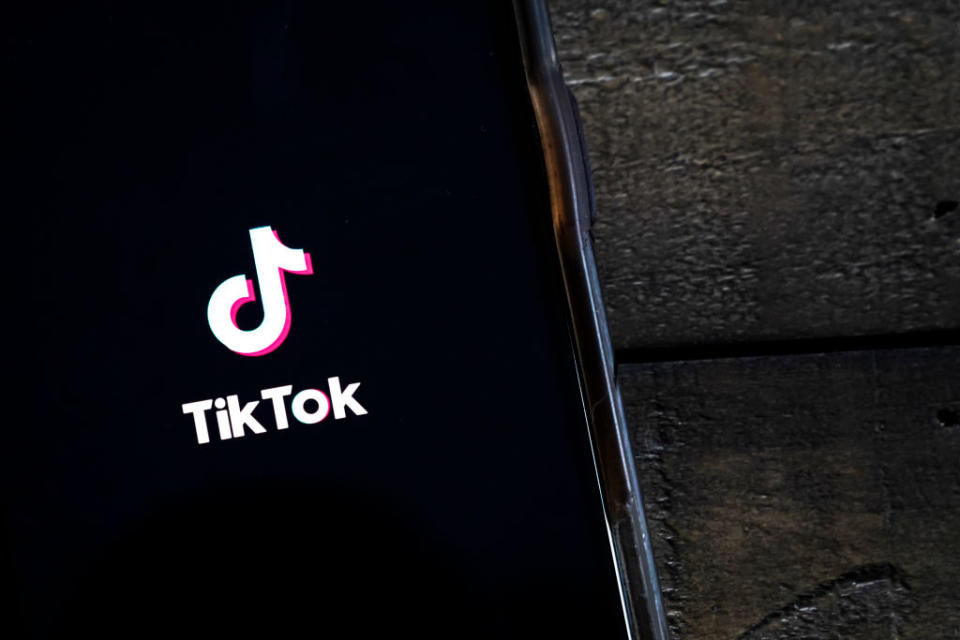 The TikTok app is displayed on an Apple iPhone