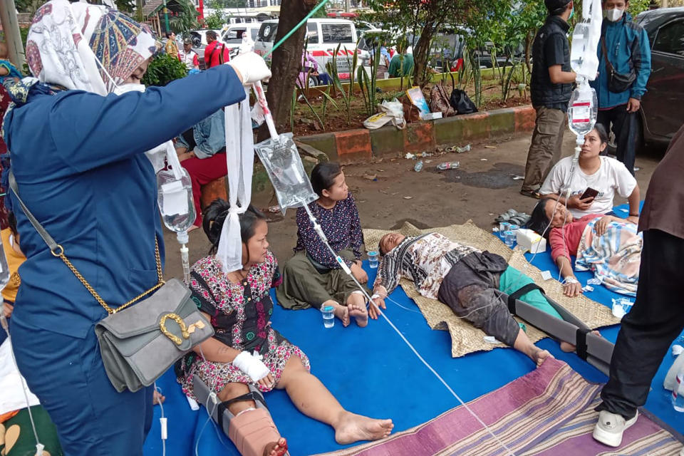 People injured during an earthquake receive medical treatment in a hospital parking lot in Cianjur, West Java, Indonesia, Monday, Nov. 21, 2022. An earthquake shook Indonesia’s main island of Java on Monday, killing a number of people, damaging dozens of buildings and sending residents into the capital's streets for safety. (AP Photo/Firman Taqur)