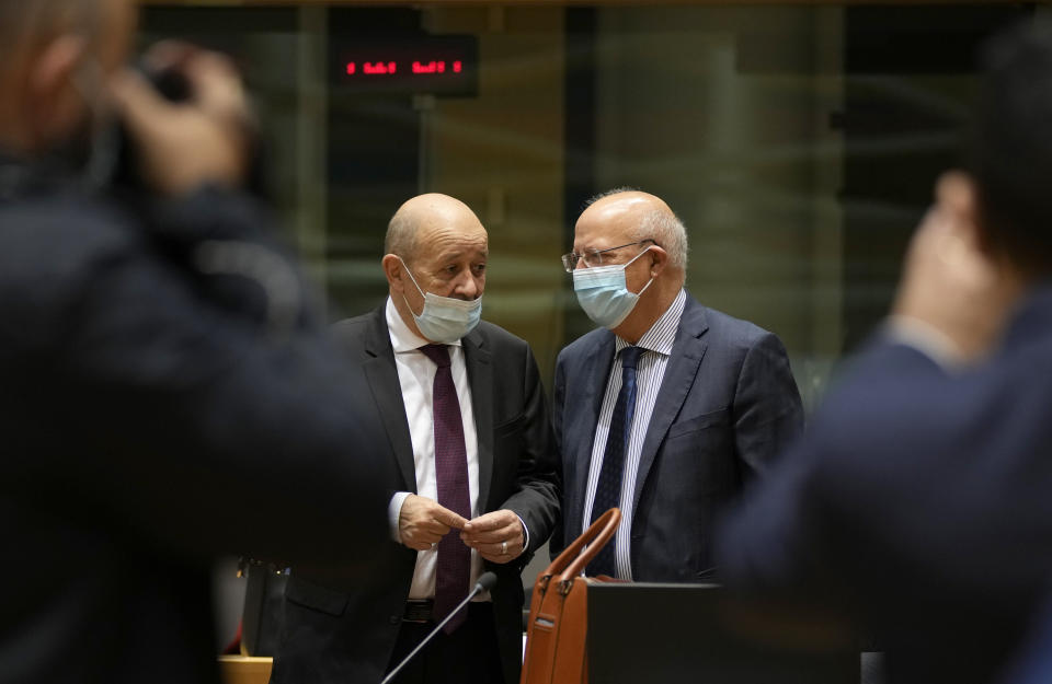 French Foreign Minister Jean-Yves Le Drian, left, speaks with Portugal's Foreign Minister Augusto Santos Silva during a meeting of EU foreign ministers at the European Council building in Brussels on Monday, Dec. 13, 2021. European Union foreign ministers met Monday to discuss how to thwart the threat of a possible new Russian invasion of Ukraine and what measures to take should Moscow decide to send its troops across the border. (AP Photo/Virginia Mayo)