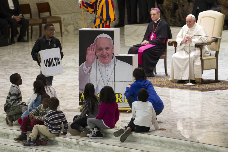 Children, assisted by volunteers of Santa Marta institute, complete a puzzle depicting Pope Francis before an audience in Paul VI hall at the Vatican December 14, 2013. REUTERS/Giampiero Sposito (VATICAN - Tags: RELIGION TPX IMAGES OF THE DAY)