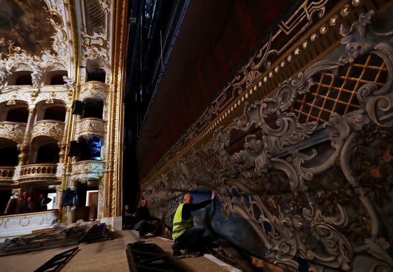 Workers install a new curtain during a general renovation of Prague's State Opera building