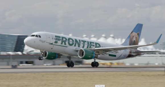 A Frontier Airlines plane landing on a runway