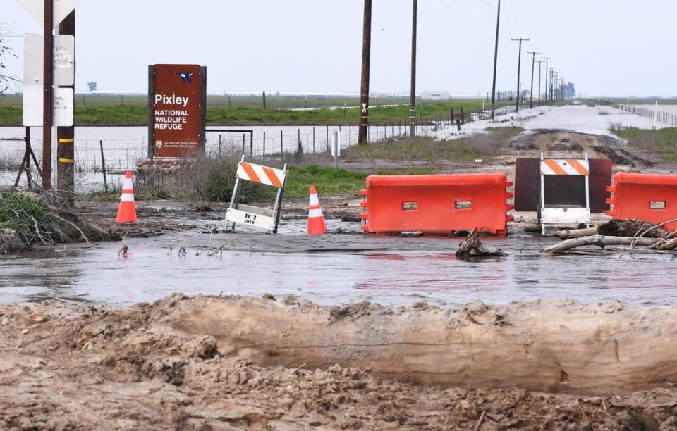 A swollen Deer Creek, foreground, has washed out a bridge along Road 88, at the Pixley National Wildlife Refuge seen northeast of Allensworth State Park Saturday afternoon, March 18, 2023.