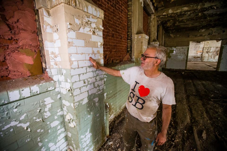 Mike Keen shows off ceramic tiles Tuesday, June 22, 2021, beneath paint in the Ward Baking Co. building in South Bend.