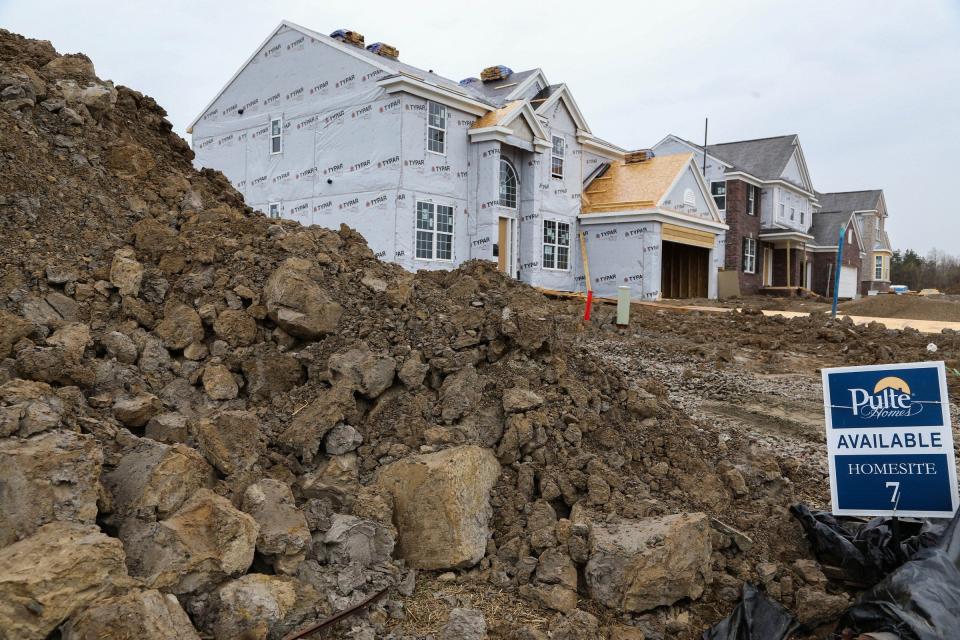 Piles of dirt sit next to an available lot as workers continue construction on houses at Stonegate West built by Pulte in Orion Township in April.