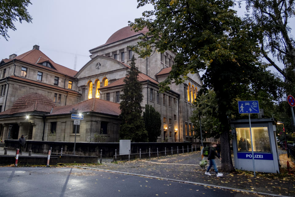 A police officer stands in a police facility, right, outside a synagogue in Frankfurt, Germany, early Thursday, Oct. 19, 2023. European Union interior ministers met Thursday to discuss how to manage the impact of the war between Israel and Hamas on the bloc, after a firebomb assault on a Berlin synagogue and killings in Belgium and France by suspected Islamist extremists. (AP Photo/Michael Probst)