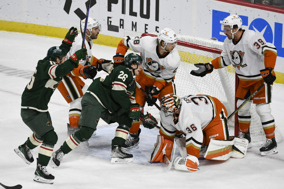 Minnesota Wild center Connor Dewar (26) pushes the puck past Anaheim Ducks goalie John Gibson (36) to score as Wild center Mason Shaw, left, celebrates and Ducks center Sam Carrick (39) and defenseman Nathan Beaulieu (28) look on during the first period of an NHL hockey game Saturday, Dec. 3, 2022, in St. Paul, Minn. (AP Photo/Craig Lassig)