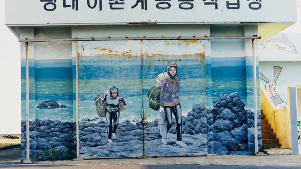 A mural depicts Haenyeo divers returning to shore with their filled nets. - Peter Ash Lee