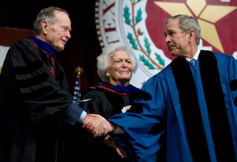 In this file photo taken on December 11, 2008 US President George W. Bush (R) shakes hands with his father, former President George H.W. Bush (L) before his mother, former First Lady Barbara Bush (C), after delivering the commencement address during the Texas A&M University graduation ceremony