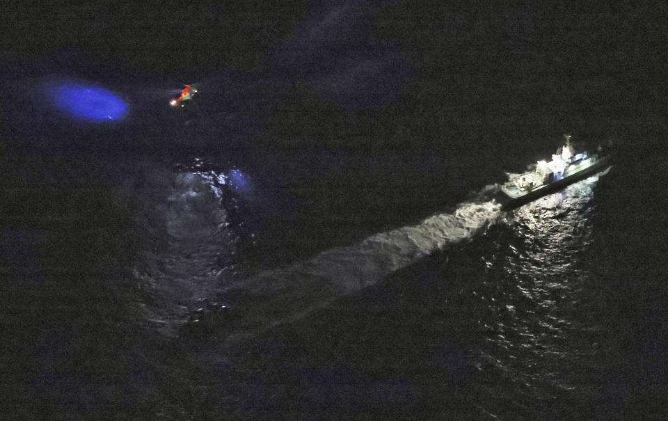 A Japan's coast guard vessel and a helicopter conduct search and rescue operation around the site where a U.S. military Osprey aircraft was believed to crash in the sea off Yakushima Island, Kagoshima prefecture, southern Japan Wednesday, Nov. 29, 2023. Japan's coast guard has found a person and debris in the ocean where a U.S. military Osprey aircraft carrying eight people crashed Wednesday off southern Japan, officials said. (Kyodo News via AP)