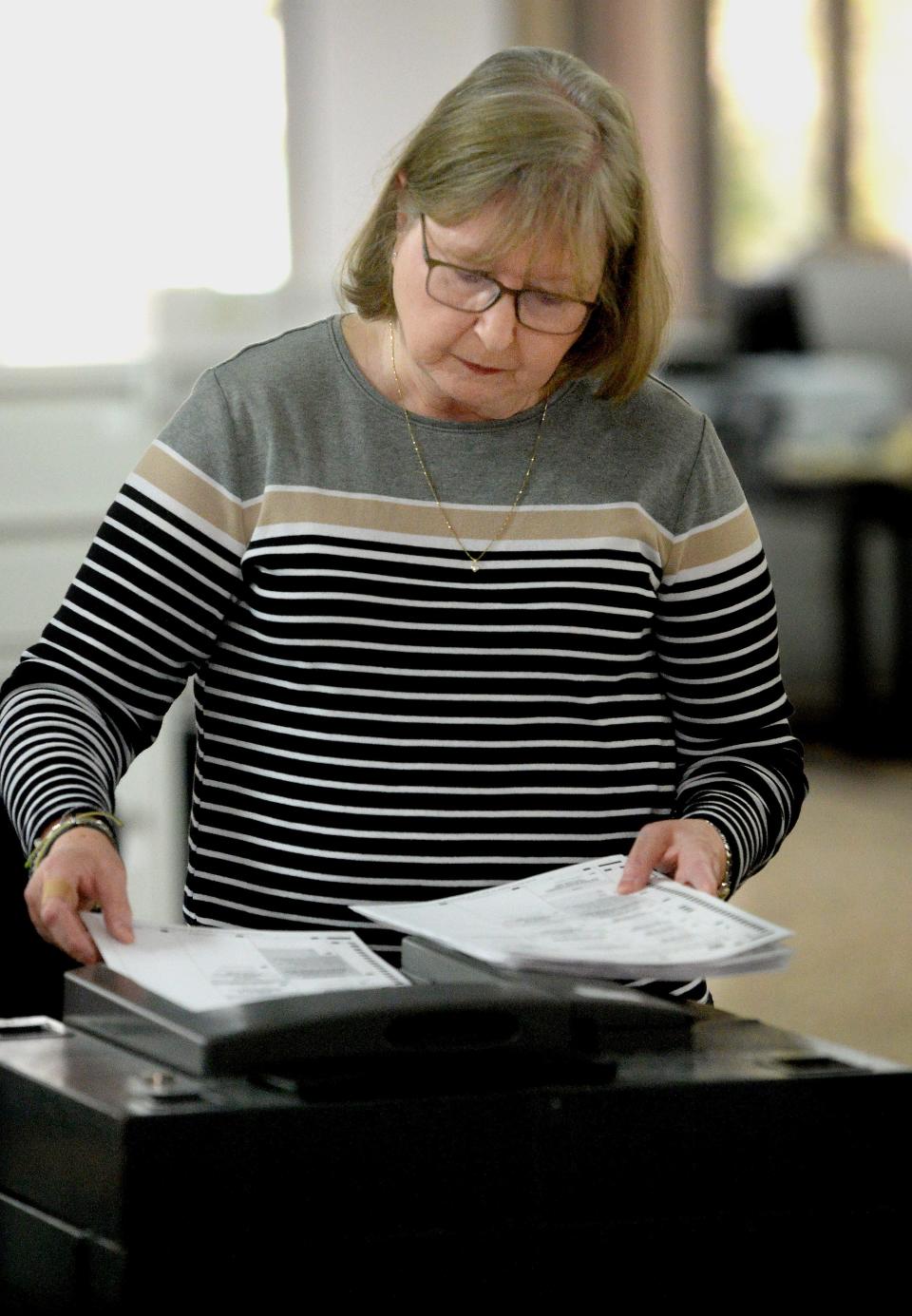 Sangamon County election judge Sheila Murdock feeds ballots into a machine to be counted on April 18, 2023.