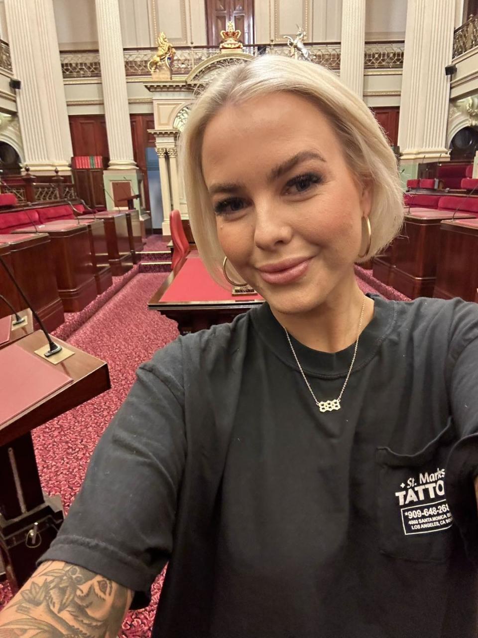 Georgie Purcell smiles for a selfie in the Victorian Parliament.