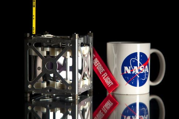 NASA's novel Phonesat 1.0 satellite is seen next to a coffee mug for size comparison. A trio of CubeSats makes up the innovative PhoneSat Project to be launched in 2013.