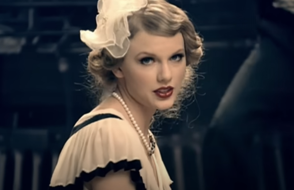 Taylor Swift in a vintage outfit with pearls and a hair accessory