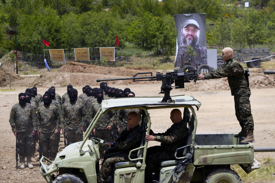 Fighters from the Lebanese militant group Hezbollah carry out a training exercise in Aaramta village in the Jezzine District, southern Lebanon, Sunday, May 21, 2023. The show of force came ahead of "Liberation Day," the annual celebration of the withdrawal of Israeli forces from south Lebanon on May 25, 2000, and in the wake of a recent escalation of the Israel-Palestine conflict in the Gaza Strip. The poster in the background of late Hezbollah military commander Imad Mughniyeh. (AP Photo/Hassan Ammar)