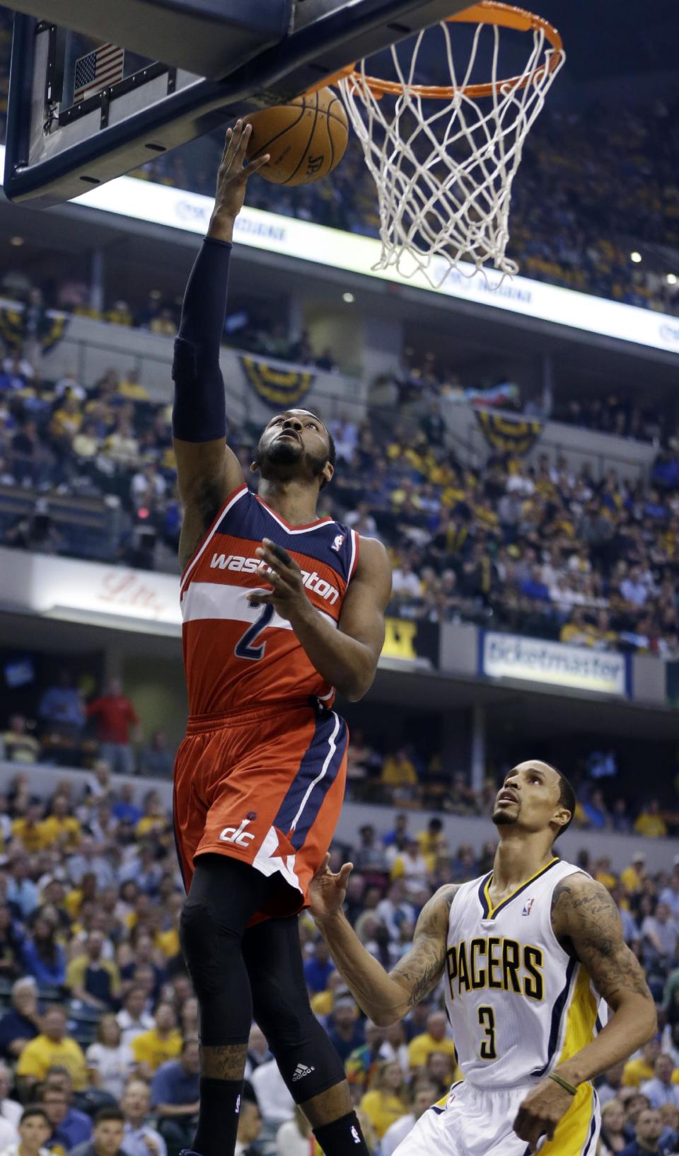 Washington Wizards' John Wall (2) puts up a shot over Indiana Pacers' George Hill (3) during the first half of game 5 of the Eastern Conference semifinal NBA basketball playoff series Tuesday, May 13, 2014, in Indianapolis. (AP Photo/Darron Cummings)