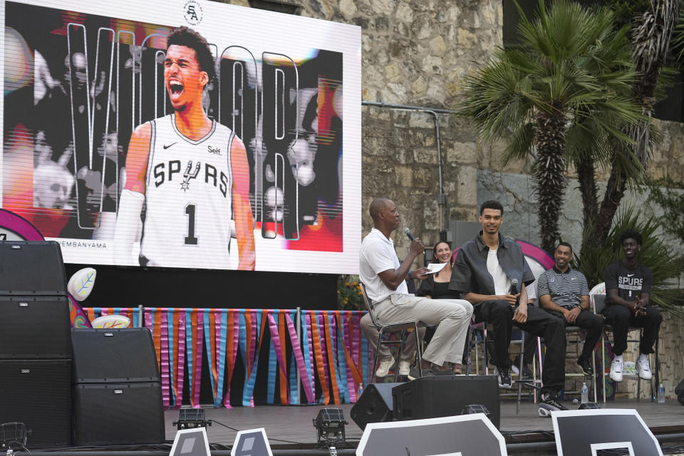 San Antonio Spurs NBA basketball draft pick Victor Wembanyama, center, is interviewed by former Spurs player Sean Elliott, left, at a meet the rookies event in San Antonio, Saturday, June 24, 2023. (AP Photo/Eric Gay)