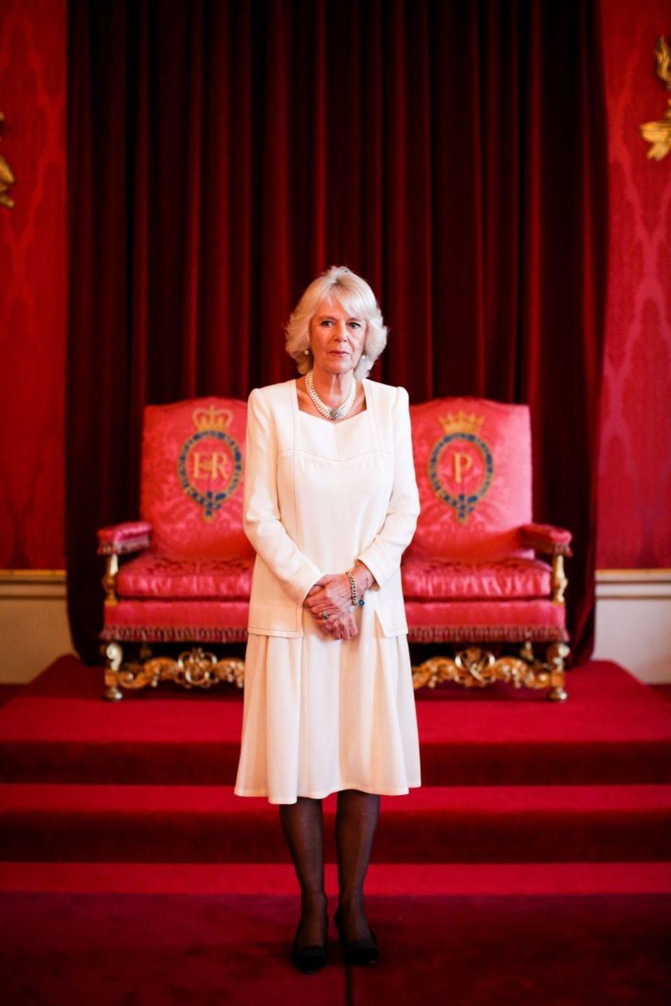 <p>Camilla hosted a reception for participants in an essay competition at Buckingham Palace wearing this understated cream dress with black hosiery and her three-strand pearl necklace. </p>