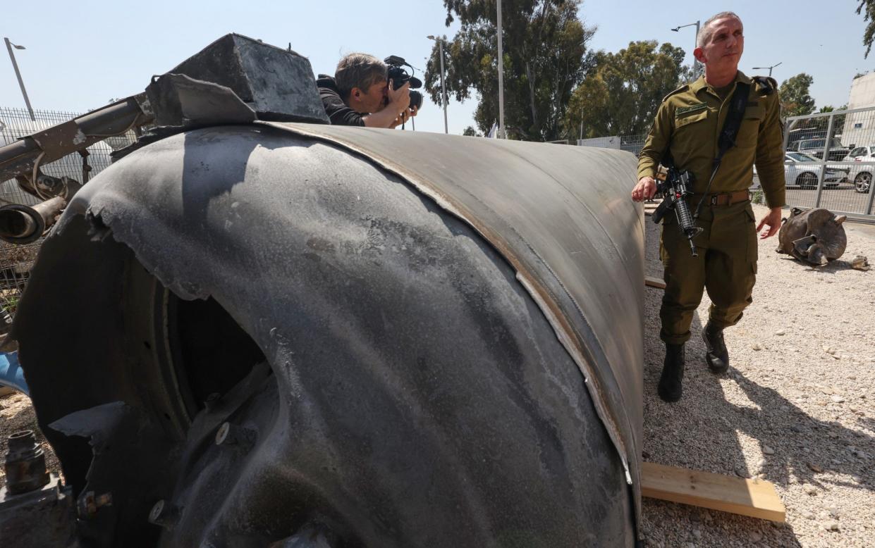 Israeli military spokesman Rear Admiral Daniel Hagari (R) poses next to an Iranian ballistic missile which fell in Israel on the weekend