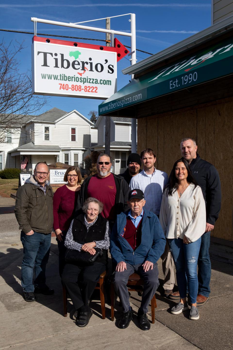 Bob and Maggie Bennett (left) stand with other new and previous owners of Tiberio's Pizza outside of the new location on Columbus Rd. on Dec. 5, 2022 in Lancaster, Ohio. 