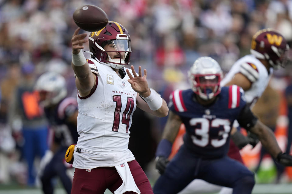 Washington Commanders quarterback Sam Howell (14) passes the ball while under pressure from New England Patriots linebacker Anfernee Jennings (33) in the second half of an NFL football game, Sunday, Nov. 5, 2023, in Foxborough, Mass. (AP Photo/Charles Krupa)