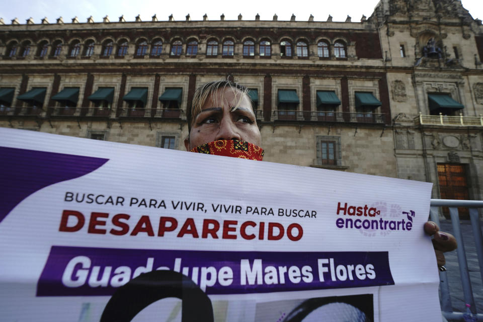 Maria de la Luz Flores holds a sign about her daughter Guadalupe Morales Flores, who she said disappeared on Sept. 7, 2020 before her body was found on March 29, 2021, during a protest demanding answers about people who go missing outside the National Palace in Mexico City, Monday, Dec. 13, 2021. (AP Photo/Marco Ugarte)