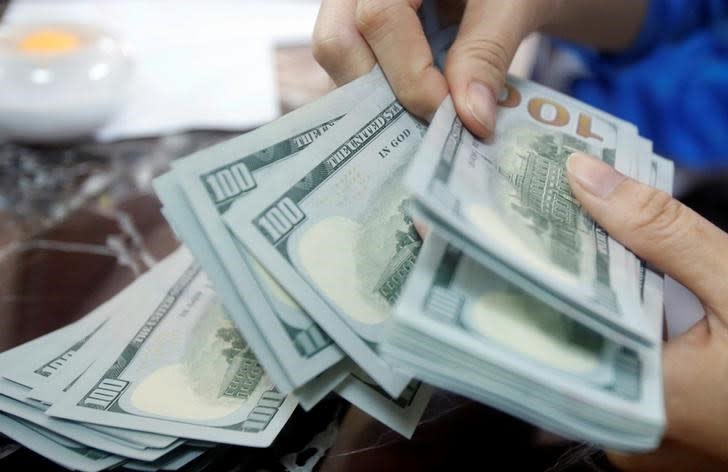 An employee of a bank counts US dollar notes at a branch in Hanoi, Vietnam May 16, 2016. REUTERS/Kham/Files