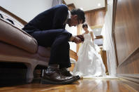 In this April 11, 2019, photo, Kenzo Watanabe smiles as his fiancee Chiharu Yanagihara tries on a wedding dress at a Japanese wedding company in Tokyo. Japan is getting ready for its biggest celebration in years with the advent of the Reiwa era of soon-to-be emperor Naruhito. That means big opportunities for businesses hoping consumers will splash out on long holidays and memorabilia. (AP Photo/Eugene Hoshiko)