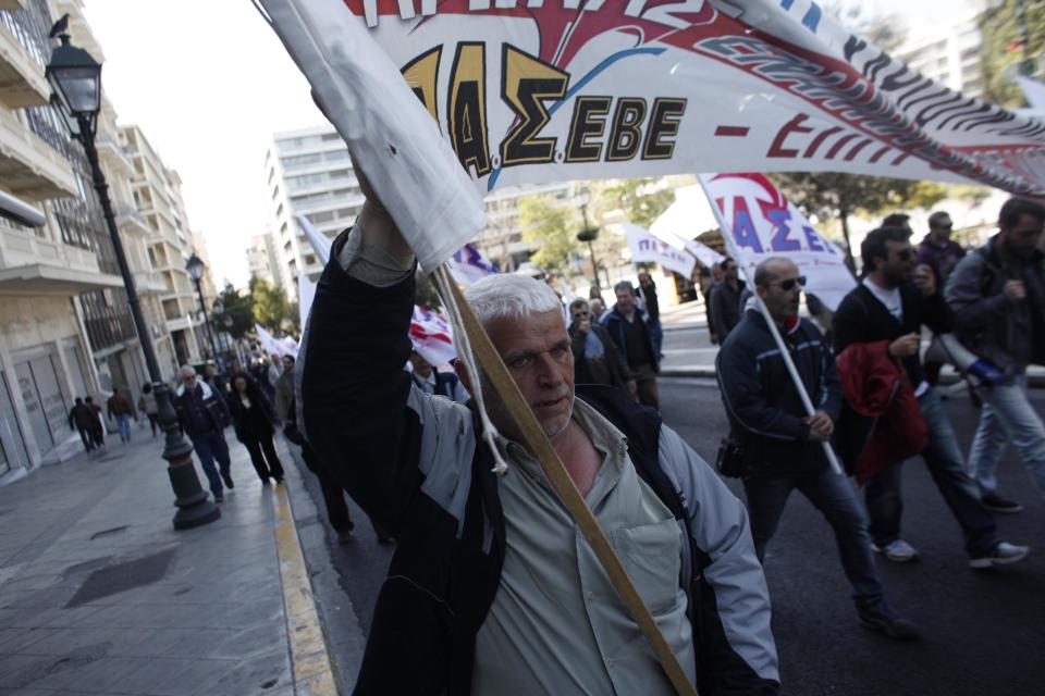 A protester holds a banner during a protest from the confederation of Professionals, Craftsmen and Merchants against a new austerity bill that will be discussed in Parliament, in Athens on Sunday, March 30 2014. The measures demanded by bailout lenders will be voted on late Sunday, and would liberalize several retail sectors. They include plans to grant supermarkets permission to set up in-store pharmacies, scrap price limits on books and allow a longer shelf-life for milk. (AP Photo/Kostas Tsironis)