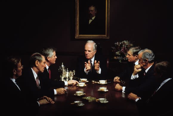 men in suits sit around a table