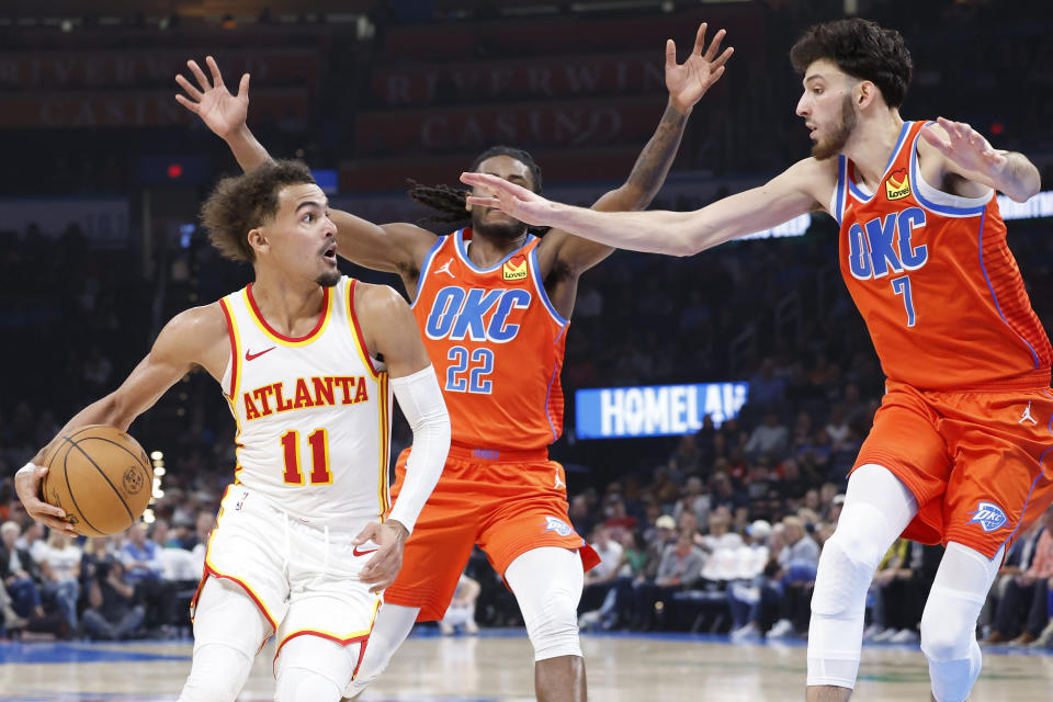 Nov 6, 2023; Oklahoma City, Oklahoma, USA; Atlanta Hawks guard Trae Young (11) is defended by Oklahoma City Thunder guard Cason Wallace (22) and forward Chet Holmgren (7) during the second quarter at Paycom Center. Mandatory Credit: Alonzo Adams-USA TODAY Sports