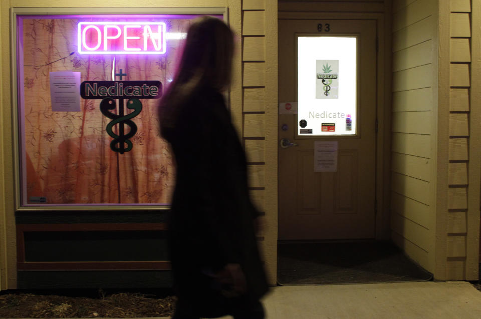 In this Nov. 19, 2012 photo, a woman walks past a medical marijuana dispensary in the small Rocky Mountain town of Nederland, Colo. On Nov. 6, 2012, Colorado and Washington state legalized the recreational use of marijuana. In Colorado it is set to take effect by Jan. 5, 2013. (AP Photo/Brennan Linsley)
