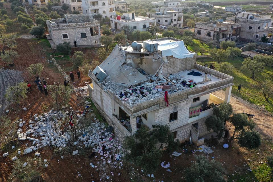 People inspect a destroyed house following an operation by the U.S. military in the Syrian village of Atmeh, in Idlib province, Syria, Thursday, Feb. 3, 2022 (AP)