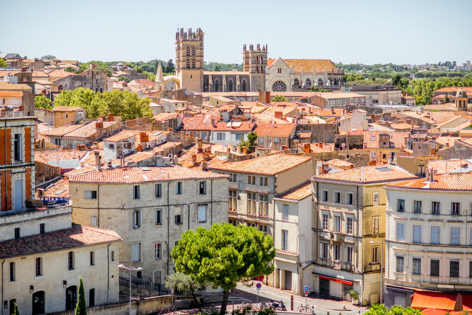 Aerial view of a historic town with dense buildings and two prominent church towers