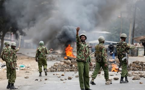 Anti riot policemen deploy after protesters set tyres on fire in Mathare, Nairobi - Credit: REUTERS