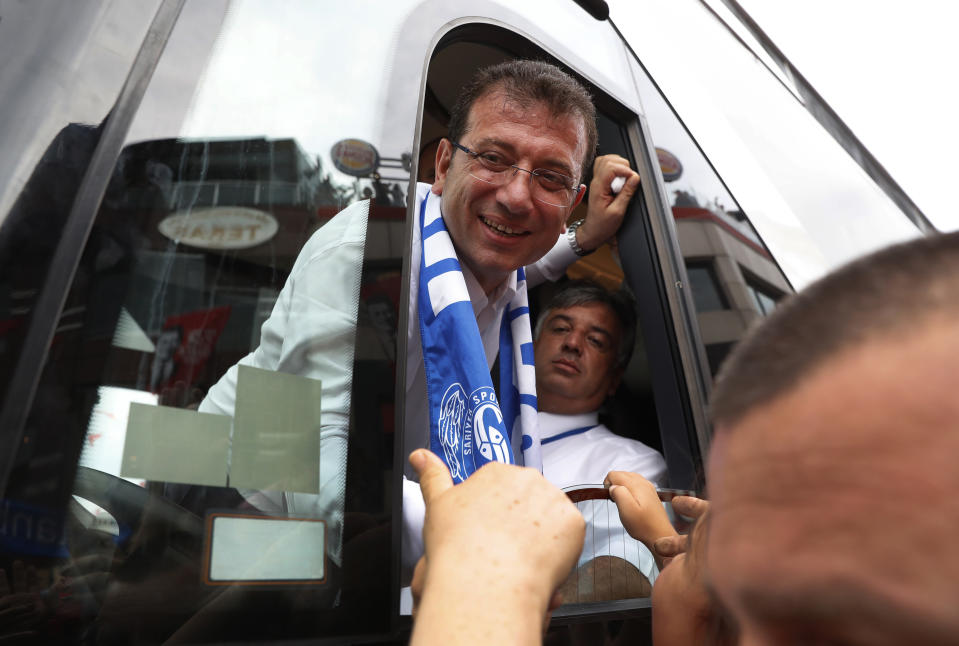 Ekrem Imamoglu, candidate of the secular opposition Republican People's Party, or CHP, reaches out from his campaign bus to shake hands with supporters following a rally in Istanbul, Friday, June 21, 2019, ahead of June 23 re-run of Istanbul elections.The 49-year-old candidate won the March 31 local elections with a slim majority, but after weeks of recounting requested by the ruling party, Turkey's electoral authority annulled the result of the vote, revoked his mandate and ordered the new election.(AP Photo/Lefteris Pitarakis)